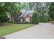 Charming two-story brick home featuring a well-manicured lawn and a long driveway surrounded by mature trees at 2770 Stonehill Way, Cumming, GA 30041