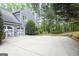 Charming two-story home with a gray exterior, a white garage door, a long driveway and lush greenery at 2770 Stonehill Way, Cumming, GA 30041