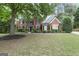 Beautiful brick home with a lush front lawn, accented by mature trees offering shade and curb appeal at 2770 Stonehill Way, Cumming, GA 30041