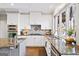 Bright kitchen with stainless appliances, granite counters, white cabinets and large window at 2770 Stonehill Way, Cumming, GA 30041