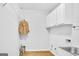 Bright laundry room with white cabinets, white beadboard detail, hardwood floors, and wire shelving at 2770 Stonehill Way, Cumming, GA 30041