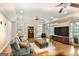 Bright living room with large windows, hardwood floors, and a cozy seating area with a television at 2770 Stonehill Way, Cumming, GA 30041