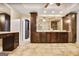Main bathroom features custom vanities with stone countertops, travertine tile, and walk-in shower at 2770 Stonehill Way, Cumming, GA 30041