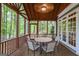 Screened porch featuring a wood ceiling, wooded views and a round table with comfortable seating at 2770 Stonehill Way, Cumming, GA 30041