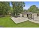 Sprawling backyard view featuring a patio, green lawn, and mature trees at 306 N Meade Dr, Peachtree City, GA 30269