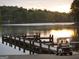 Scenic view of a wooden dock, with a golf cart and couple watching the sunset over the lake at 306 N Meade Dr, Peachtree City, GA 30269