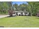 Attractive single-story house featuring a well-manicured lawn, trees, and landscaping at 306 N Meade Dr, Peachtree City, GA 30269