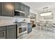 Elegant kitchen with stainless steel stove and gray cabinets flows into dining area at 306 N Meade Dr, Peachtree City, GA 30269
