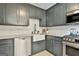 A stylish kitchen boasts gray cabinets, stainless appliances, and a farmhouse sink at 306 N Meade Dr, Peachtree City, GA 30269