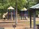 Image of a playground with a slide and various climbing structures in a wooded park setting at 306 N Meade Dr, Peachtree City, GA 30269