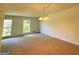 Sunny dining room with large windows, neutral carpet, and classic chandelier lighting at 1753 Brenda Dr, Jonesboro, GA 30236