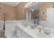 Well-lit bathroom featuring double sinks, white cabinetry, and a large mirror at 1302 Eddie Craig Ct, Mcdonough, GA 30252