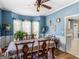 Bright dining room with blue walls, a ceiling fan, large windows, and a beautifully set table at 1302 Eddie Craig Ct, Mcdonough, GA 30252