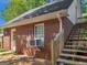 Brick home exterior with stairs leading to a side entrance, featuring a window AC unit at 1302 Eddie Craig Ct, Mcdonough, GA 30252