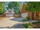 View of a brick home with a detached garage, showcasing a large driveway and well-maintained landscaping at 1302 Eddie Craig Ct, Mcdonough, GA 30252