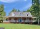 Inviting brick home featuring a full-width covered porch with white railings, perfect for enjoying the outdoors at 1302 Eddie Craig Ct, Mcdonough, GA 30252