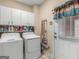 Well-equipped laundry room with washer, dryer, storage cabinets, and access to the exterior at 1302 Eddie Craig Ct, Mcdonough, GA 30252