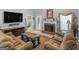 Cozy living room featuring a brick fireplace, plush seating, and a large flat screen television at 1302 Eddie Craig Ct, Mcdonough, GA 30252