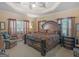 Spacious main bedroom with a tray ceiling, large bed, and abundant natural light from multiple windows at 1302 Eddie Craig Ct, Mcdonough, GA 30252
