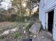 Backyard with overgrown weeds, discarded debris, and a deteriorating structure at 305 Fairburn Nw Rd, Atlanta, GA 30331