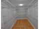 Walk-in closet with custom shelving and hardwood floors at 2647 Mount Carmel Rd, Hampton, GA 30228