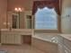 Primary bath with jacuzzi tub, tiled floors, and vanity at 187 Eagles Club Dr, Stockbridge, GA 30281