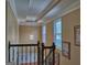 Bright hallway with tray ceiling, chandelier, decorative railing, and natural light from windows at 187 Eagles Club Dr, Stockbridge, GA 30281