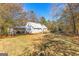 Backyard featuring the house, a deck, a shed, and mature trees at 75 Antioch Rd, Mcdonough, GA 30252