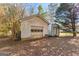 View of detached garage and shed surrounded by trees and fallen leaves at 75 Antioch Rd, Mcdonough, GA 30252