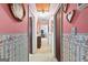 Hallway with floral wallpaper, carpeted floor, and doorways to various rooms at 75 Antioch Rd, Mcdonough, GA 30252