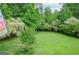 Lush backyard featuring a well-maintained lawn and mature trees, offering a serene outdoor space at 830 Montego Sw Way, Lilburn, GA 30047