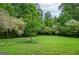 Lush backyard featuring a well-maintained lawn and mature trees, offering a serene outdoor space at 830 Montego Sw Way, Lilburn, GA 30047