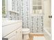 Bathroom features a vanity with storage, floral wallpaper, tile flooring, and window that brings in natural light at 830 Montego Sw Way, Lilburn, GA 30047