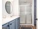 Modern bathroom with double sink vanity, walk-in shower with glass doors, and tile flooring at 830 Montego Sw Way, Lilburn, GA 30047