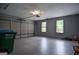 Spacious garage with clean epoxy flooring, ample storage, and natural light from the windows at 830 Montego Sw Way, Lilburn, GA 30047