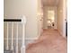 Upstairs hallway leads to bedrooms and features neutral paint, carpet and natural light at 830 Montego Sw Way, Lilburn, GA 30047