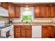 Kitchen with wooden cabinets, granite countertops, white appliances, and a window with a view at 830 Montego Sw Way, Lilburn, GA 30047