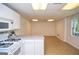 Cozy basement kitchenette with stove, microwave, white cabinets, and view to unfinished area at 830 Montego Sw Way, Lilburn, GA 30047