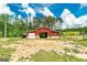 Well-maintained red barn with an open bay, situated on a large, grassy lot at 107 Corinth Reserve Pl, Grantville, GA 30220
