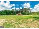 A classic red barn sits surrounded by a vast, open field with a backdrop of lush greenery at 107 Corinth Reserve Pl, Grantville, GA 30220
