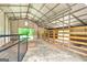 Spacious barn featuring a metal roof, partial fencing, and ample natural light for livestock and equipment storage at 107 Corinth Reserve Pl, Grantville, GA 30220