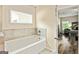 The bathroom features a tub with ceramic tile backsplash with window and entry to bedroom at 107 Corinth Reserve Pl, Grantville, GA 30220