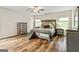 Main bedroom with a decorative bed, dresser, hardwood floors, and lots of light at 107 Corinth Reserve Pl, Grantville, GA 30220