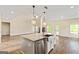 Kitchen island with a stainless steel sink and a view of the large, open concept living space at 107 Corinth Reserve Pl, Grantville, GA 30220