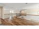 Second story loft area with wood look flooring and iron railing overlooking the stairs at 107 Corinth Reserve Pl, Grantville, GA 30220