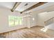 Bright living room with wood beams, hardwood floors, and a modern light fixture at 107 Corinth Reserve Pl, Grantville, GA 30220