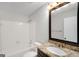 Bright bathroom features a tub with white tile surround, granite countertop, and modern fixtures at 27 Lakes Edge Se Dr, Smyrna, GA 30080