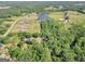 Expansive aerial view showcasing the property's vast land, serene pond, and surrounding lush greenery at 701 Mask Rd, Brooks, GA 30205