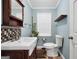 Well-lit bathroom featuring a stylish vessel sink, dark wood accents, and a neutral-toned checkerboard backsplash at 701 Mask Rd, Brooks, GA 30205