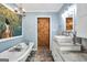 Charming bathroom featuring a standalone tub, vessel sink, stone countertop, and a barn-style door at 701 Mask Rd, Brooks, GA 30205